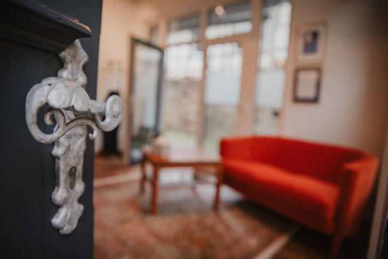 Dekorativer Türgriff im Fokus; geöffnete Tür gewährt Einblick in stilvollen Raum bei Lebenskreise Bestattungen, Gau-Algesheim.