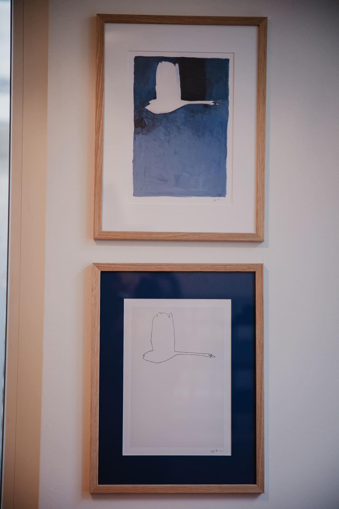 Zwei gerahmte Vogelbilder hängen übereinander - ein farbiges oben, darunter eine schlichte Zeichnung. Impression aus unseren Räumen.